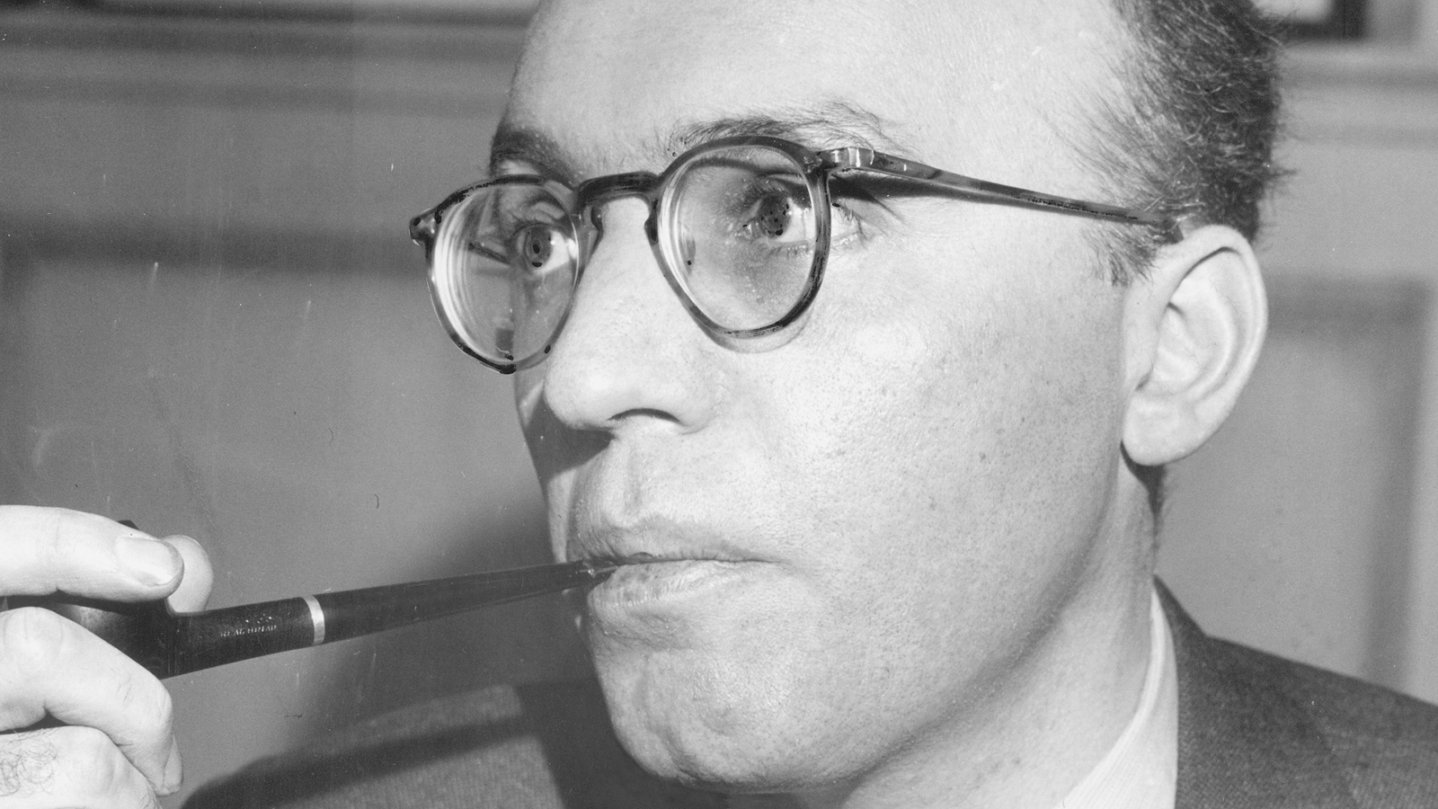 Black and white photo of Kurt Weill smoking a pipe.