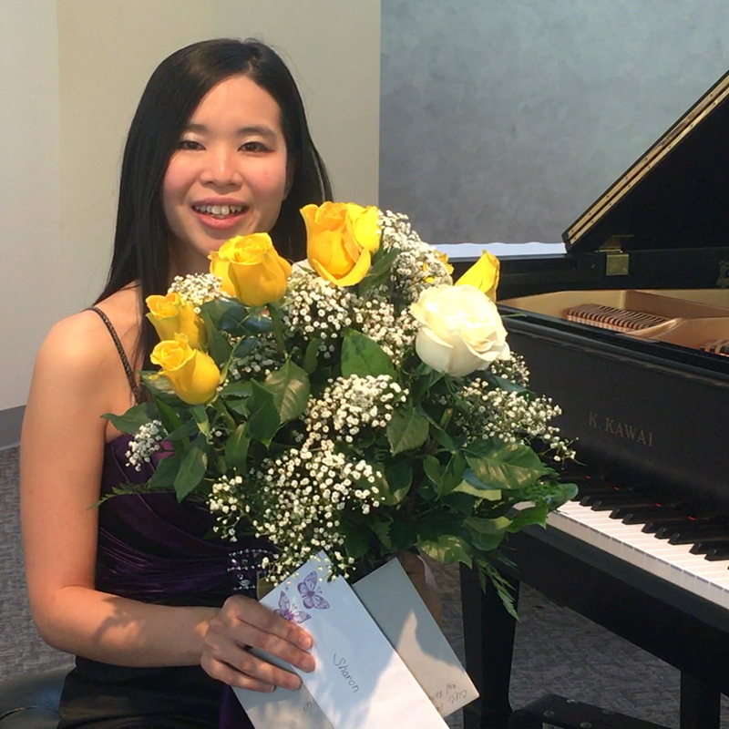  Hui Shan How at the piano holding flowers.