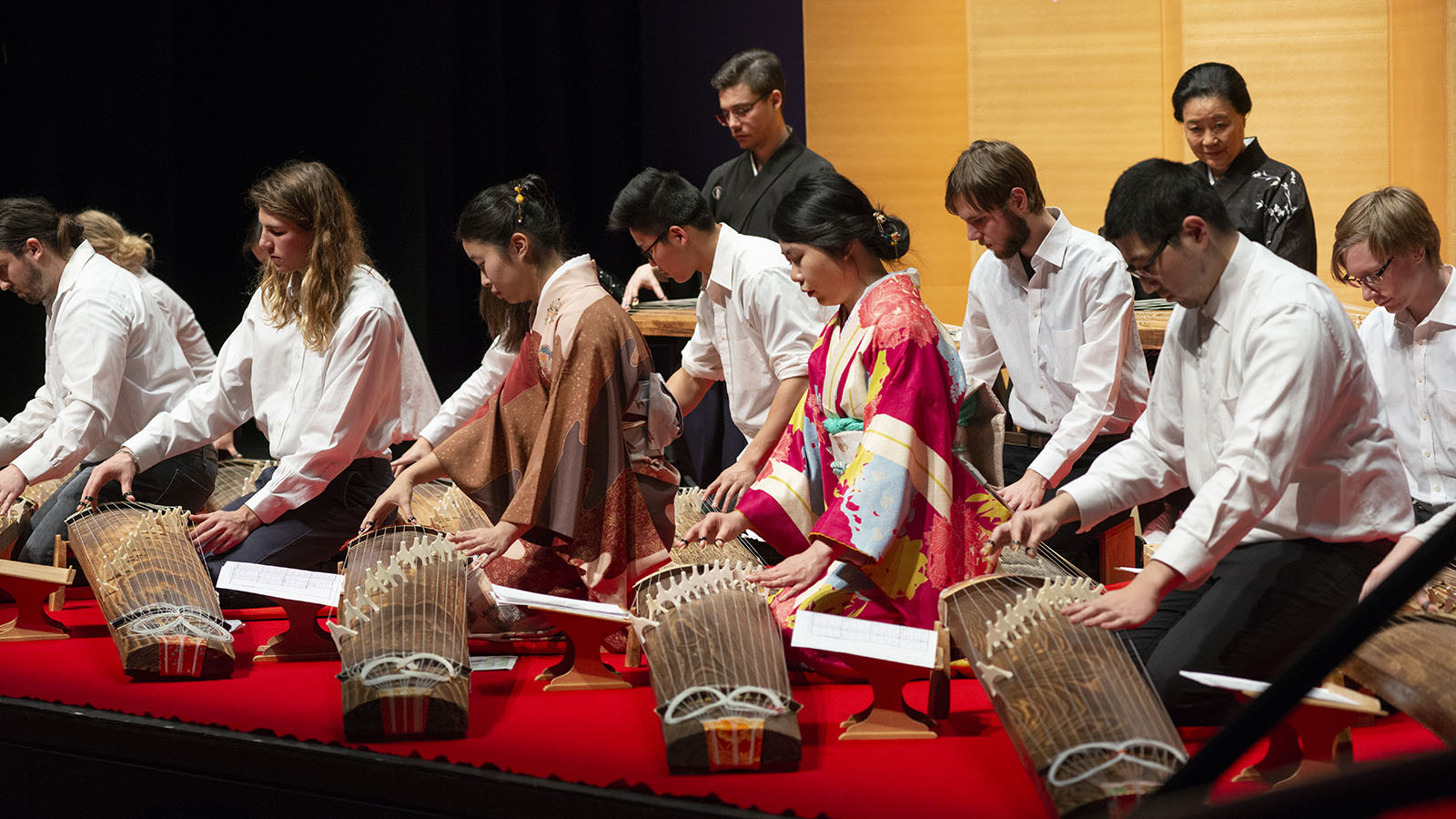 Students playing on Japanese koto instruments.